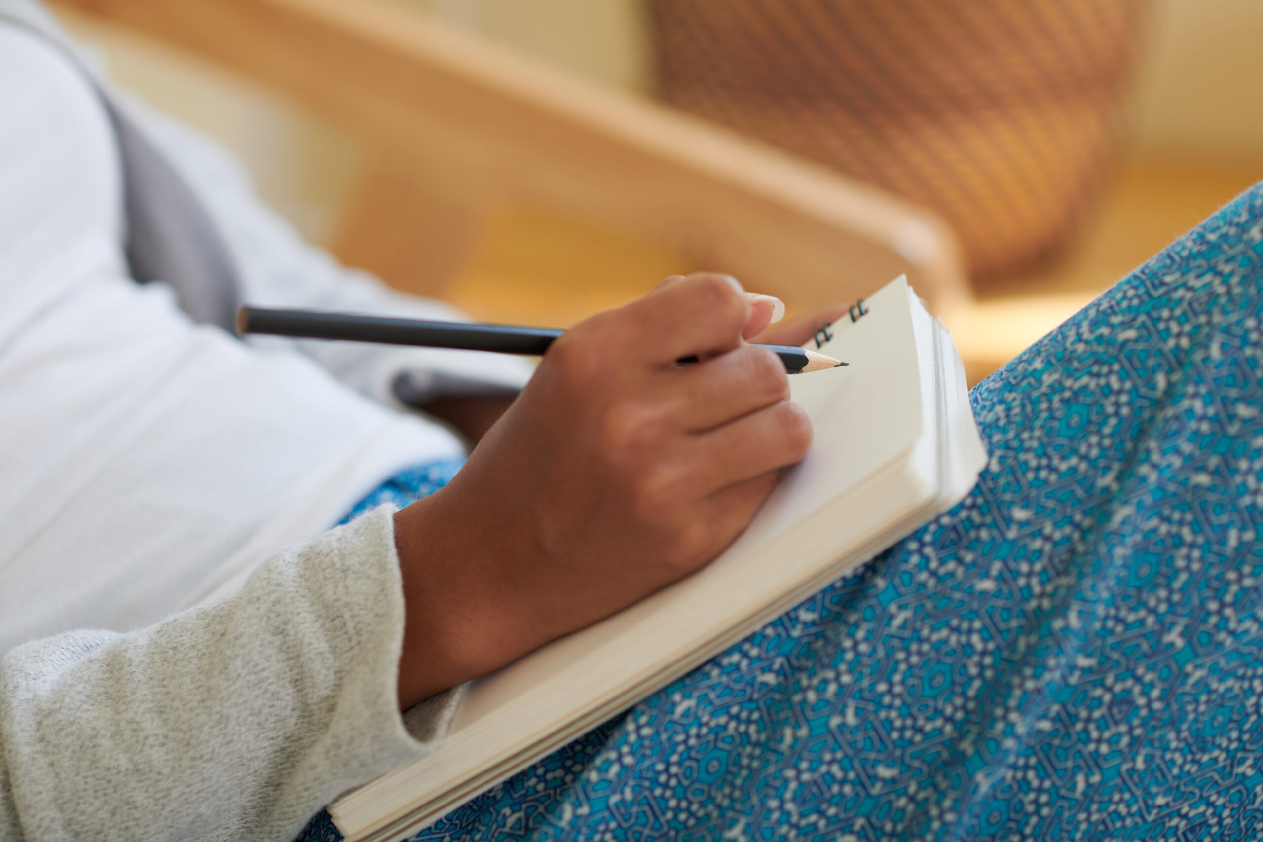 Close-up image of young woman writing in diary her thoughts and ideas